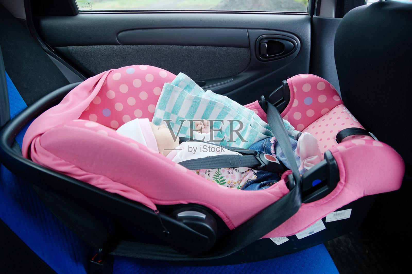 新生儿睡在汽车座椅上。安全的概念。婴儿的女婴。安全驾驶与儿童。可爱的婴儿睡在车里。照片摄影图片