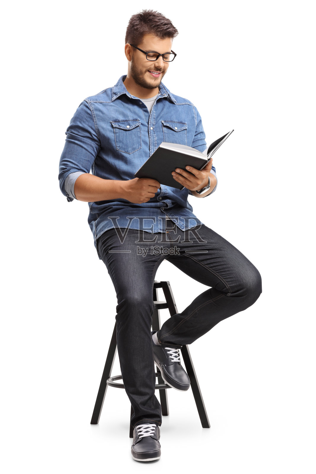 一个坐在椅子上看书的家伙照片摄影图片
