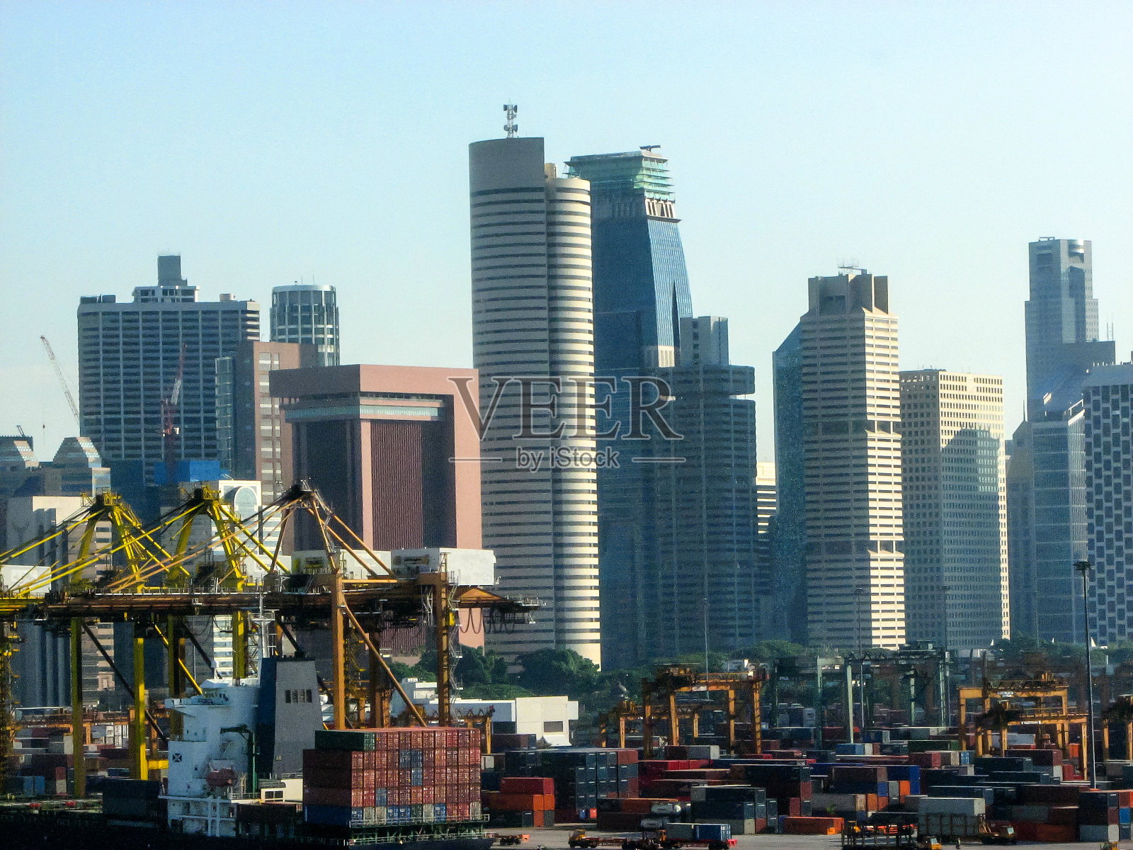 在新加坡，集装箱码头的背景是现代化的高楼大厦照片摄影图片