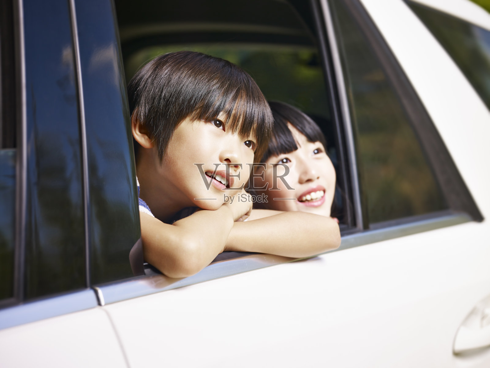 两个亚洲孩子在看风景，而旅行的汽车照片摄影图片