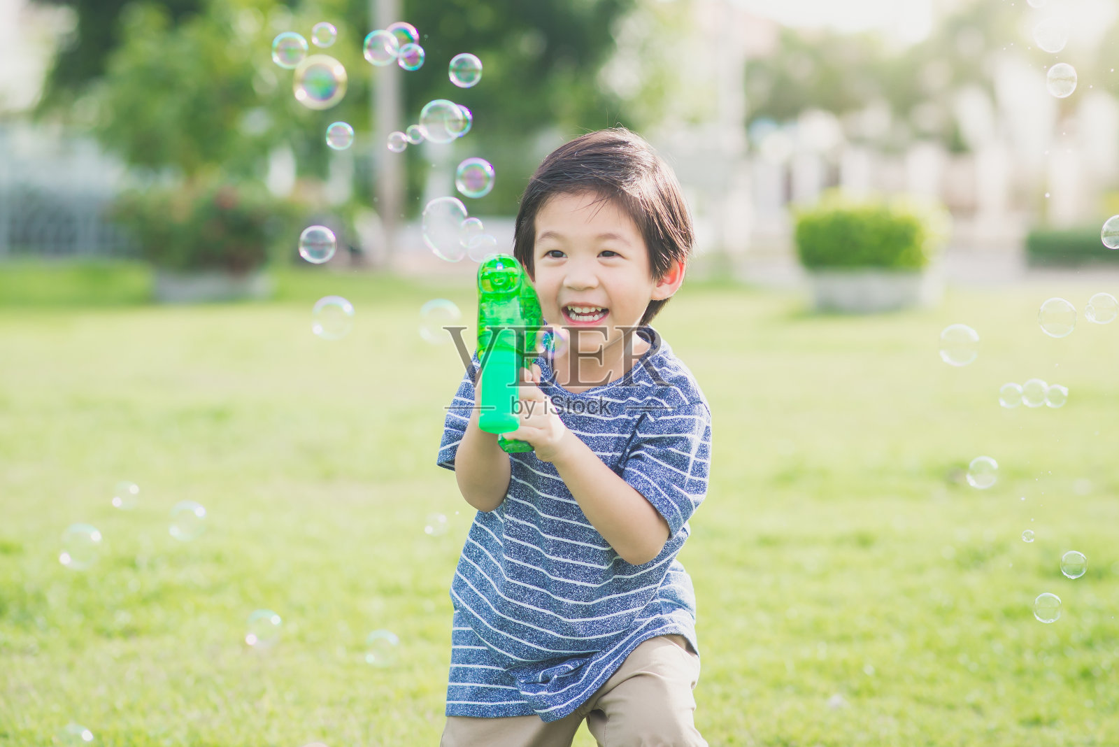 亚洲小孩用泡泡枪射击泡泡照片摄影图片