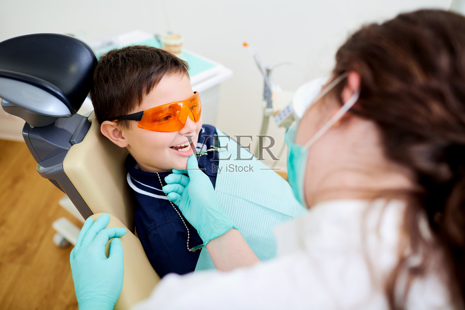 一个小孩在牙科诊所看牙医。牙科treatme照片摄影图片
