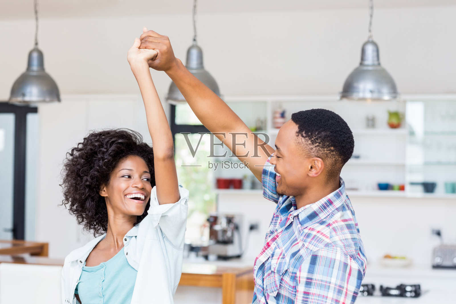 快乐的情侣在厨房跳舞照片摄影图片