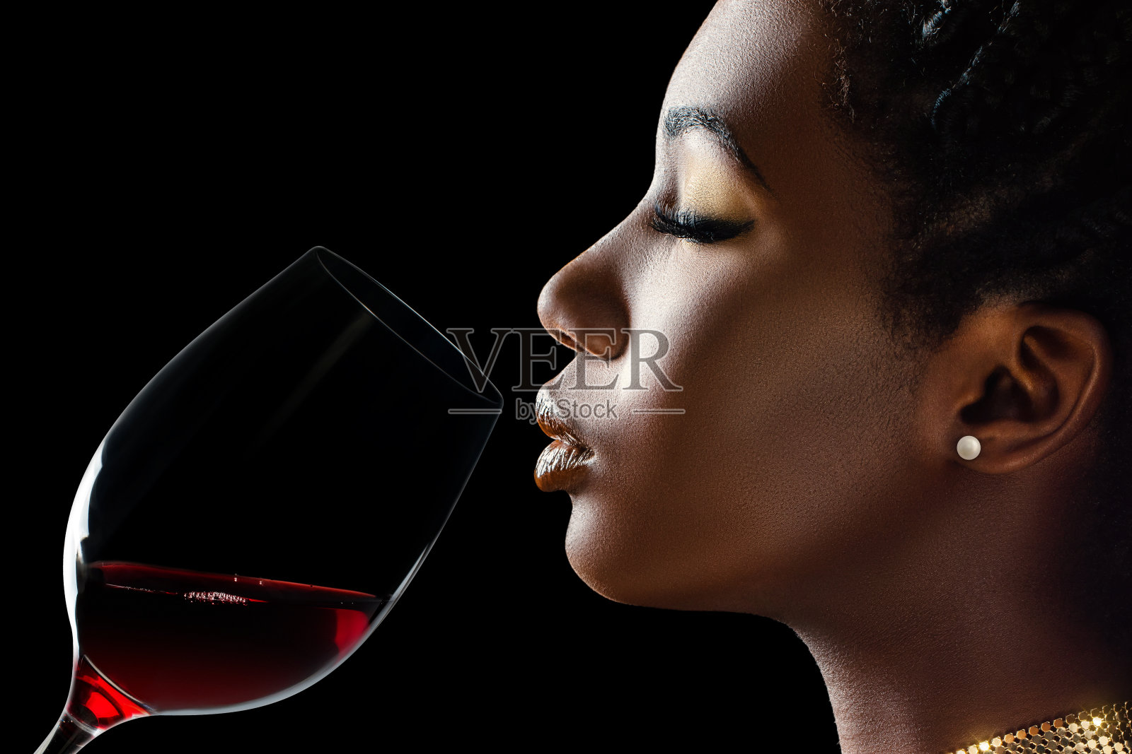 闻着红酒香气的非洲女人。照片摄影图片
