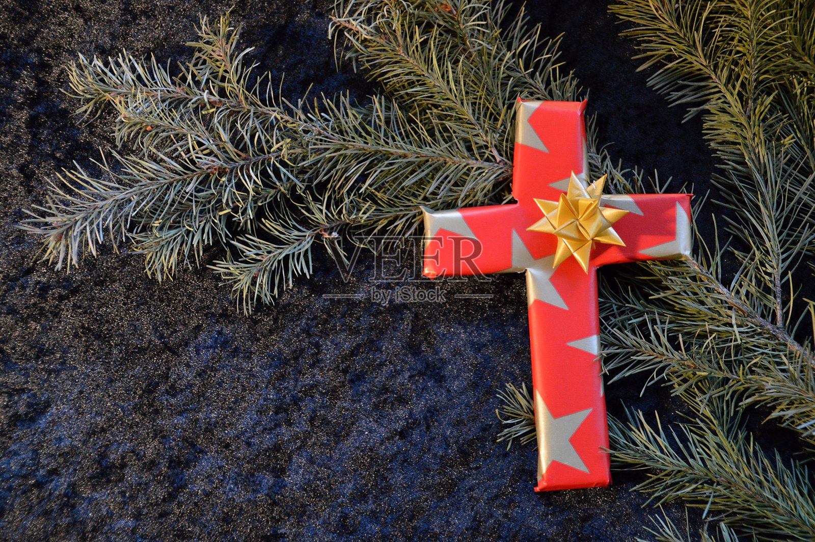 在圣诞节用纸包着的十字架作为礼物。照片摄影图片