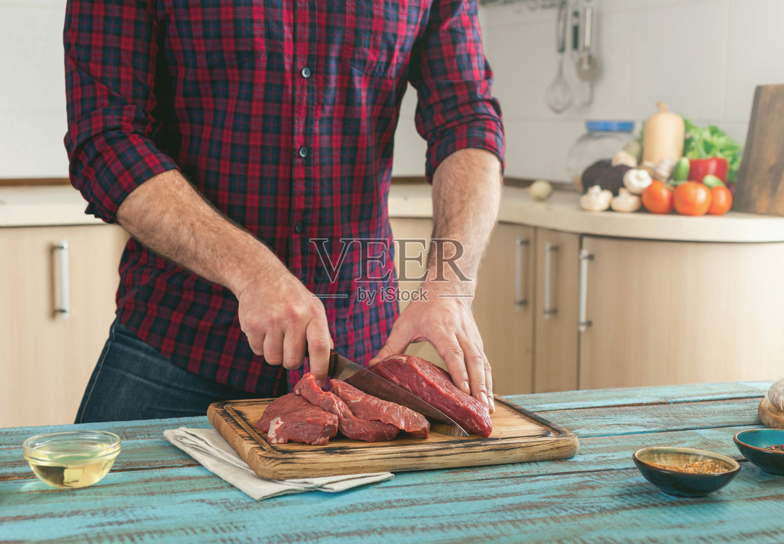 男人在一块木板上切新鲜的牛肉照片摄影图片