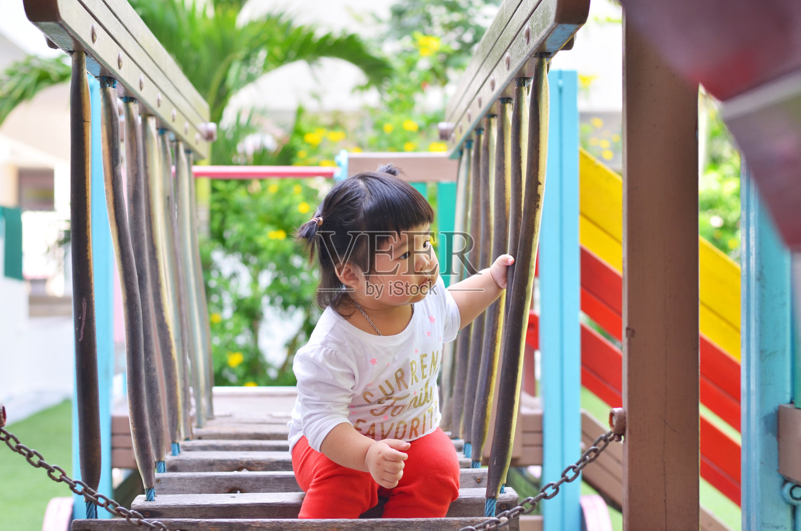 亚洲小女孩寻找朋友在泰国游乐场玩照片摄影图片