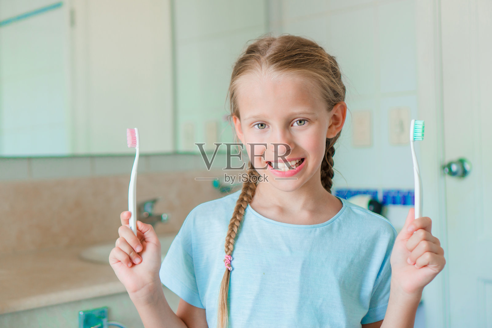 微笑的小女孩在浴室刷牙照片摄影图片