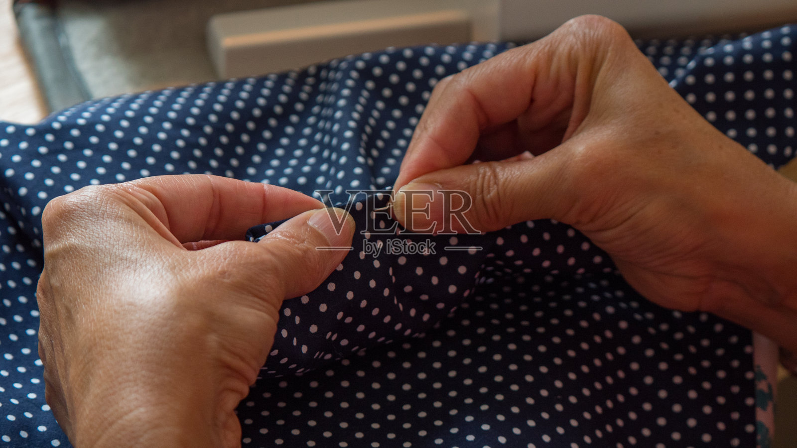 女性手钉和缝制织物照片摄影图片
