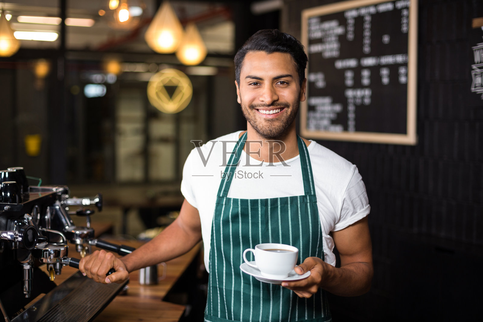 微笑的咖啡师用咖啡机煮咖啡照片摄影图片