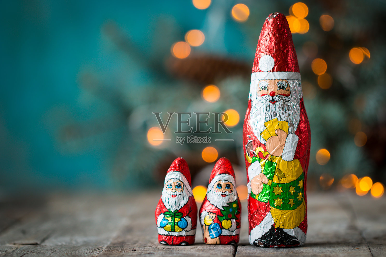巧克力圣诞老人和圣诞灯在一个古老的木制背景。圣诞节的概念照片摄影图片