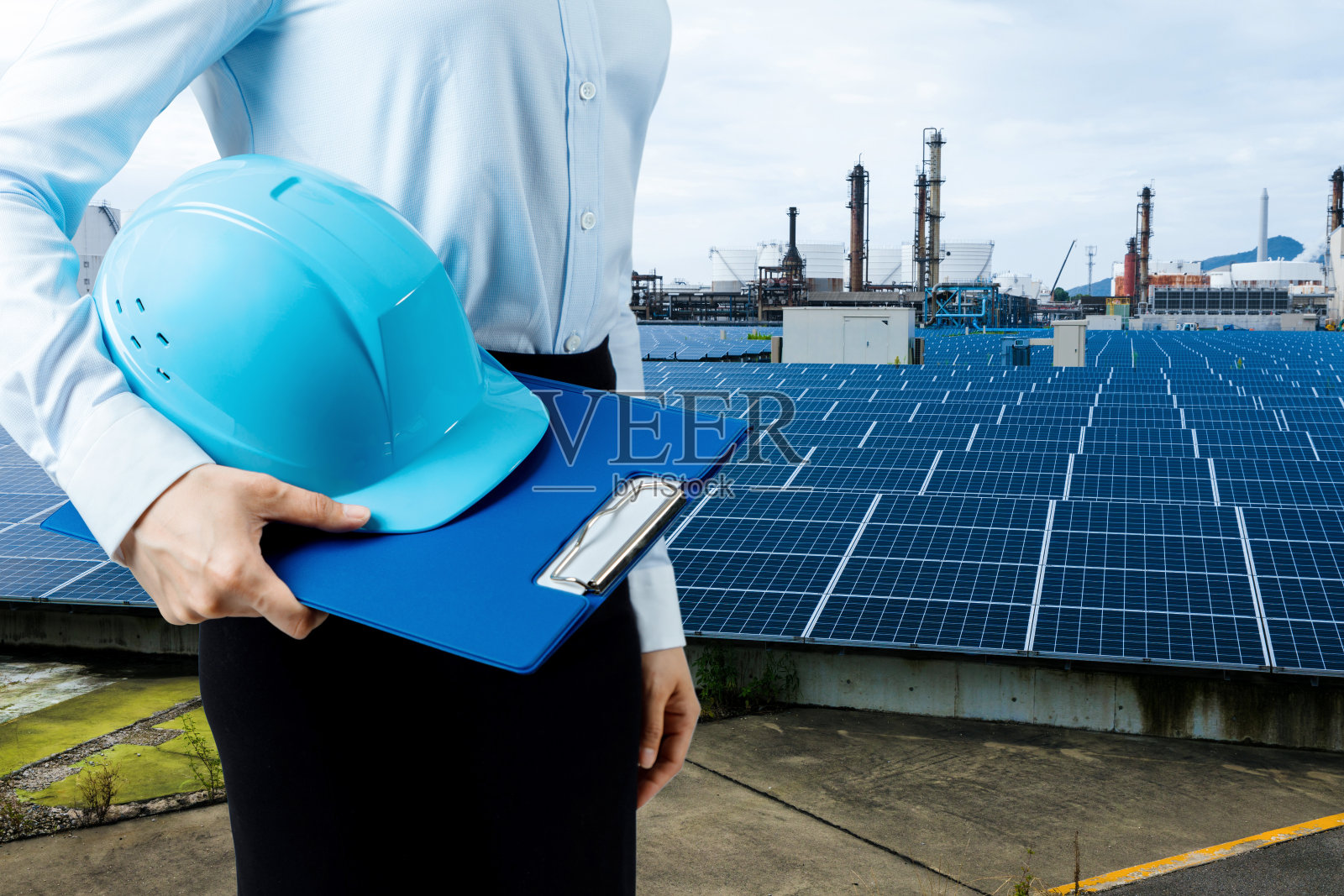 工程师手持头盔和太阳能发电厂。可再生能源的概念。照片摄影图片