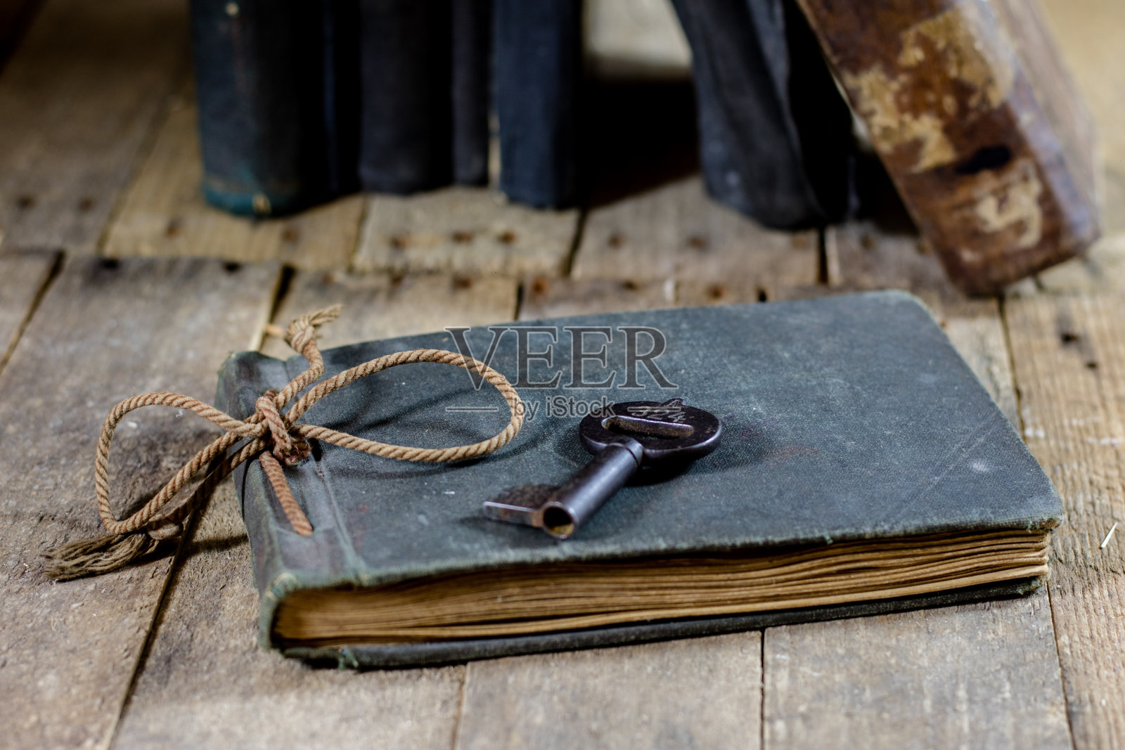 很旧的书和钥匙放在一张旧木桌上。旧房间，木桌和带钥匙的书，黑色背景照片摄影图片