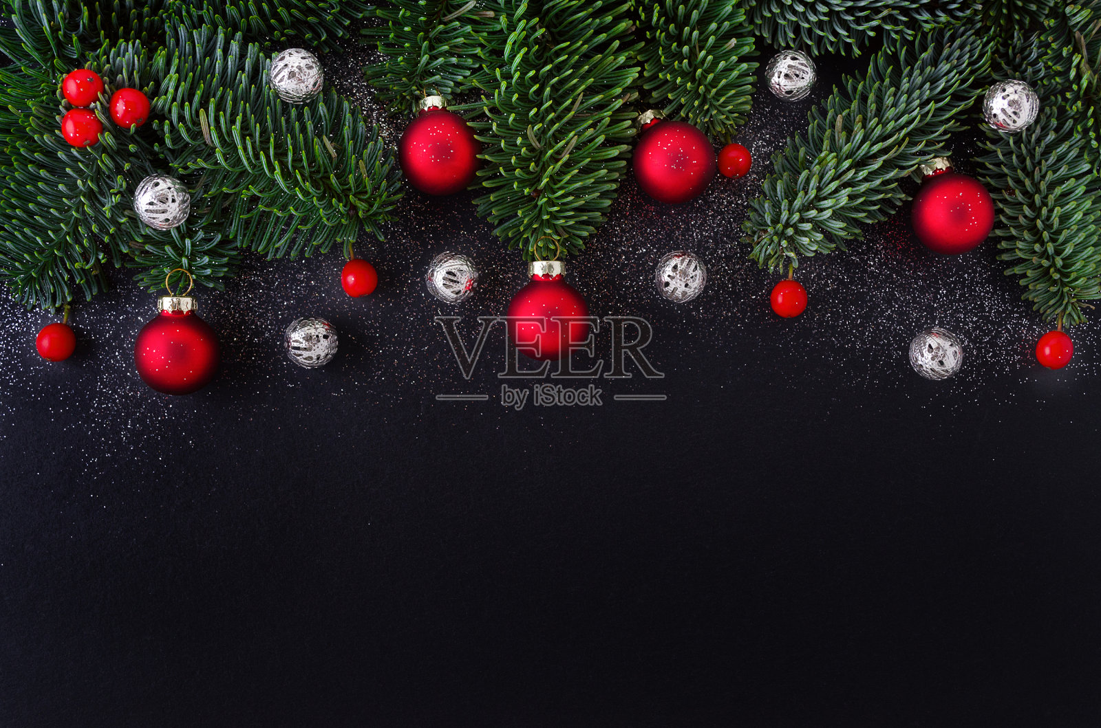 圣诞节的黑色背景装饰，红莓，小玩意和冷杉树枝照片摄影图片