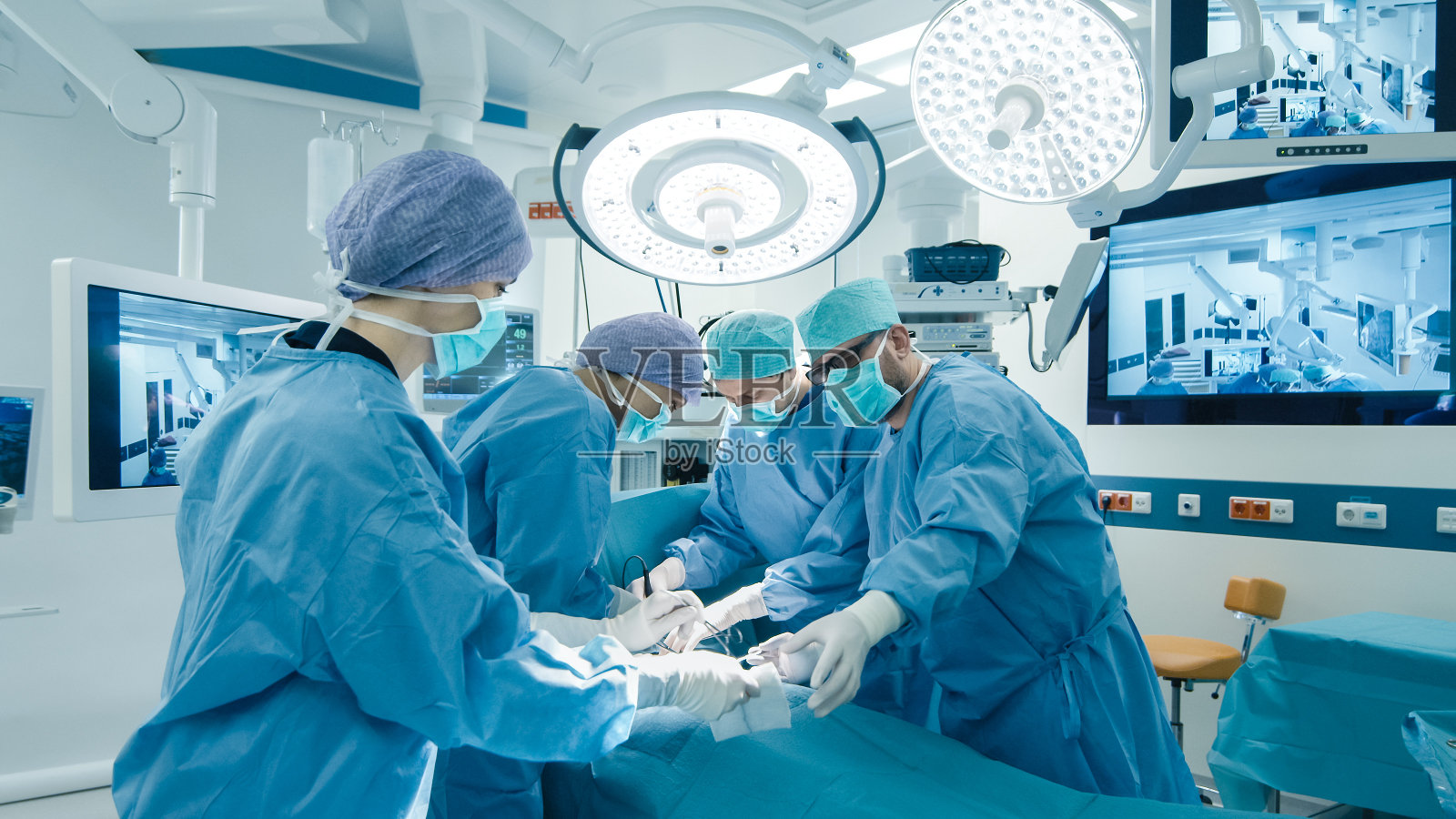 医疗队在明亮的现代手术室进行外科手术照片摄影图片