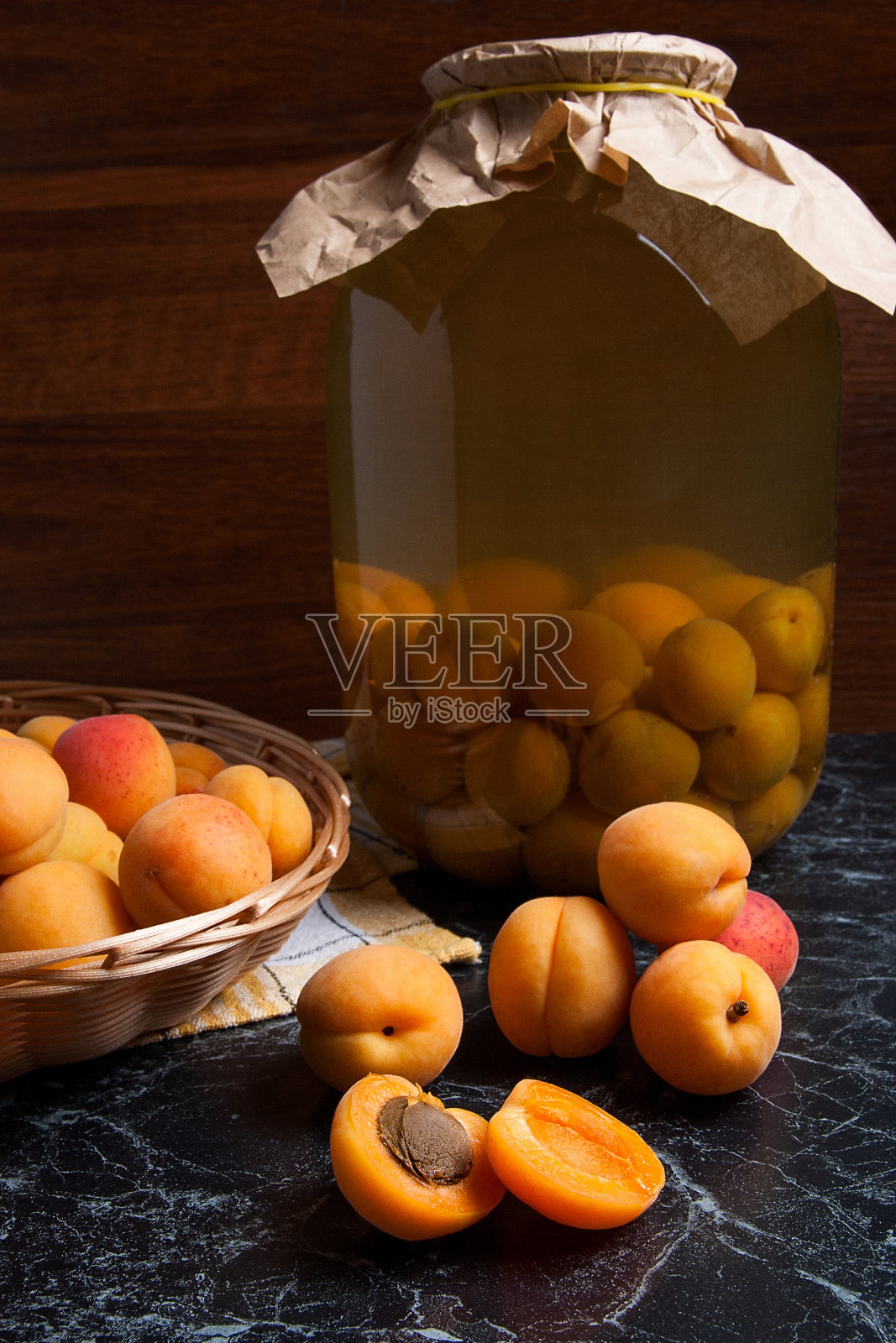收获的杏子在篮子和玻璃罐与杏子果盘照片摄影图片