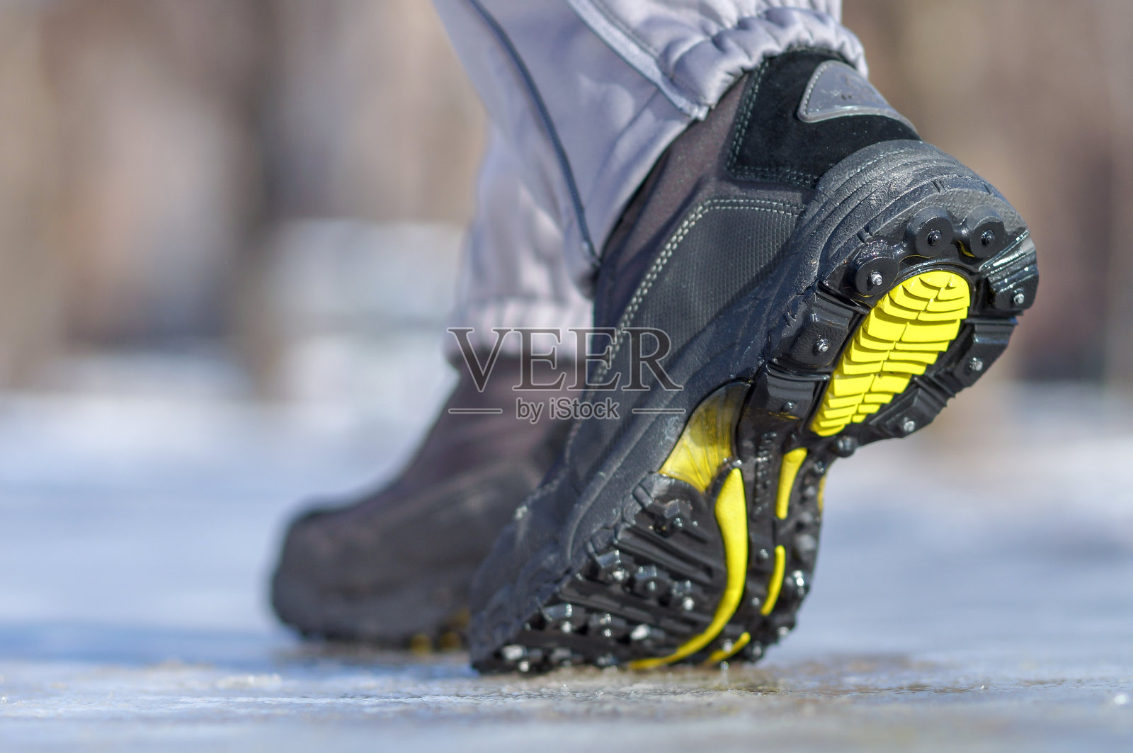 冬天的腿穿着靴子走在冰雪覆盖的路上照片摄影图片