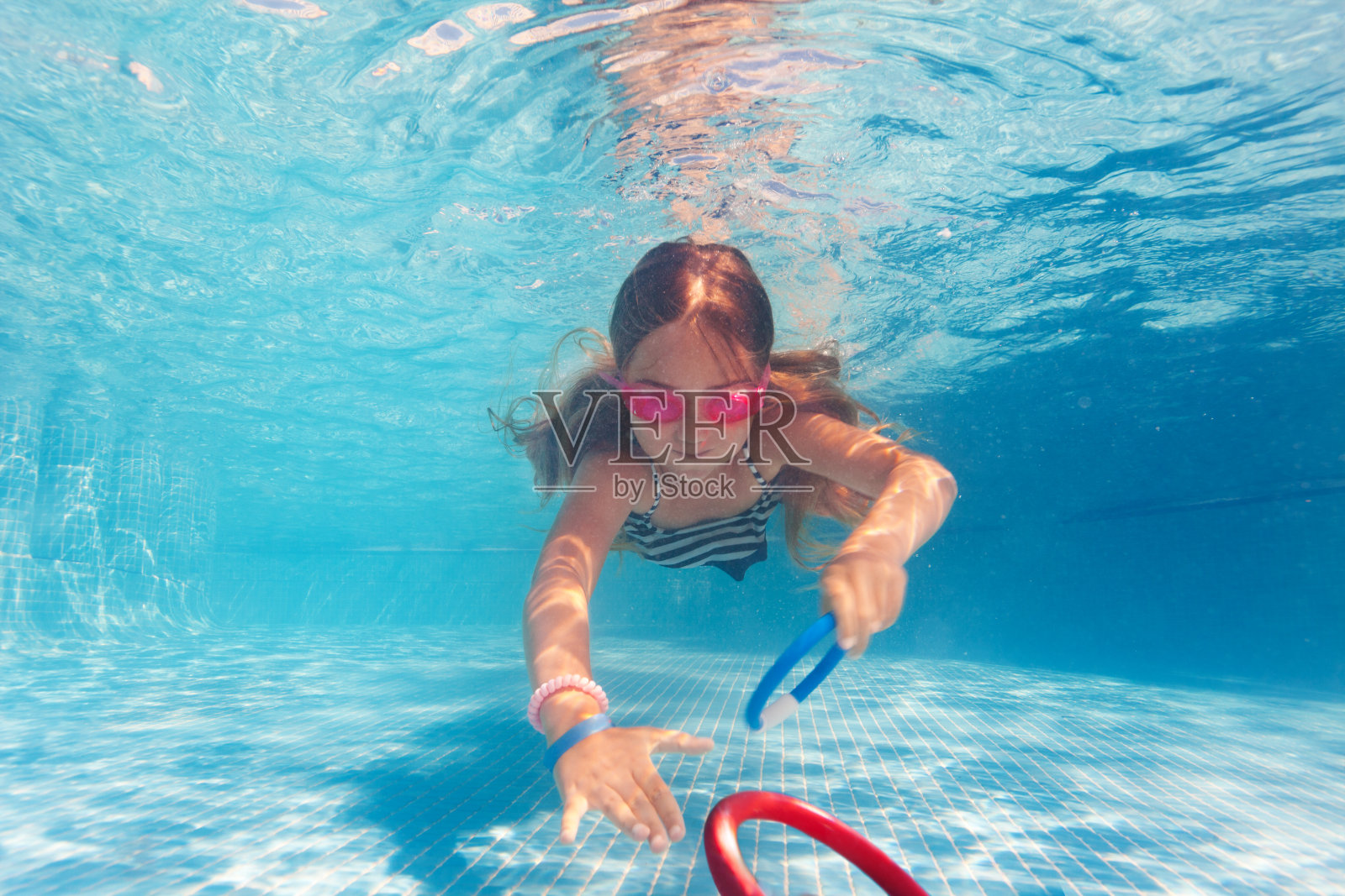 十多岁的女孩戴着粉色护目镜在水下训练照片摄影图片
