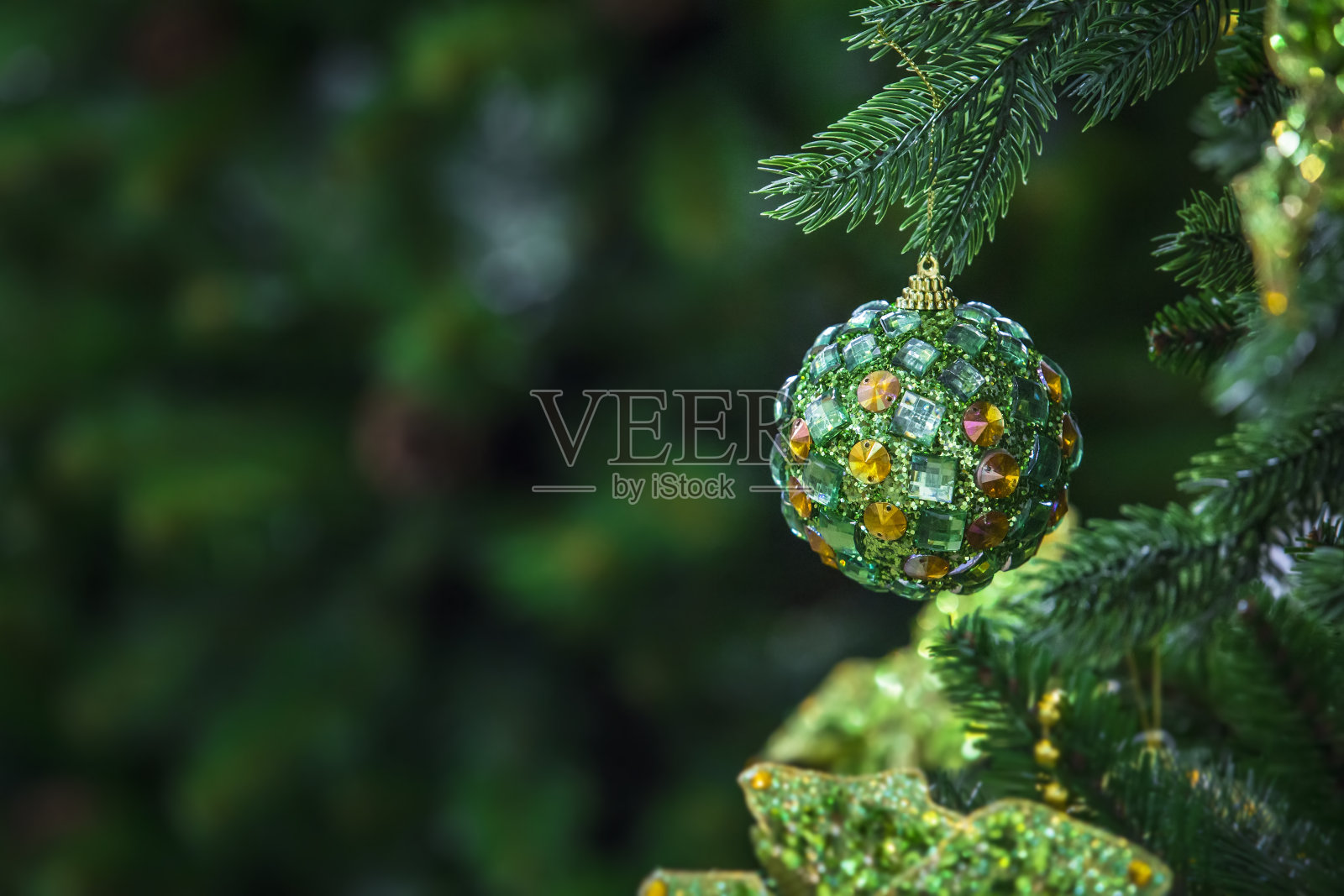 绿色的圣诞球挂在圣诞树上，现代的球用水晶装饰照片摄影图片