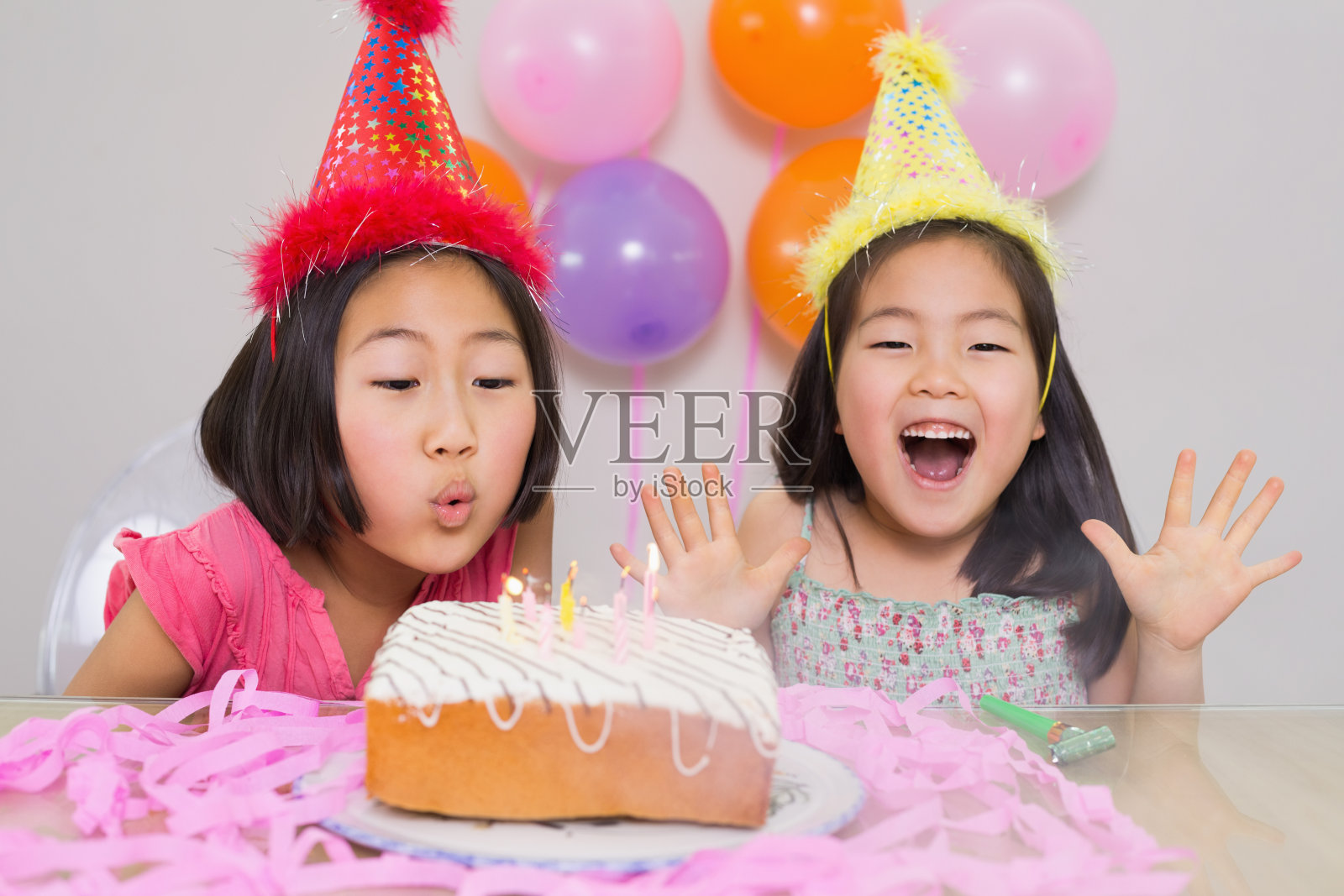 年轻女孩在生日派对上吹蛋糕照片摄影图片