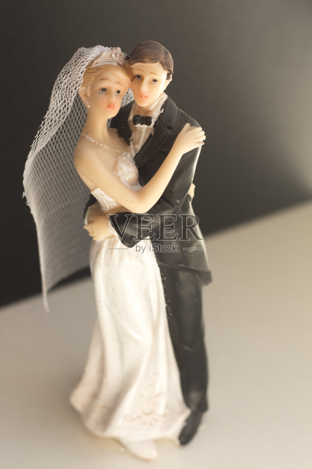 新娘和新郎的婚礼蛋糕顶部塑料雕像举行婚礼仪式后。照片摄影图片