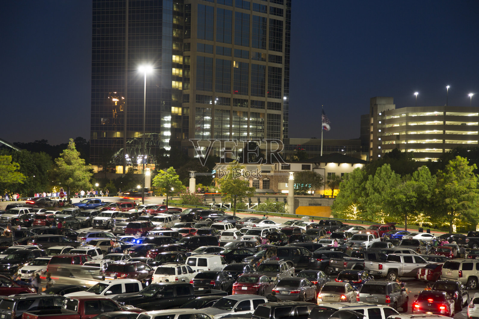 晚上，城市购物中心区域的停车场挤满了人。照片摄影图片