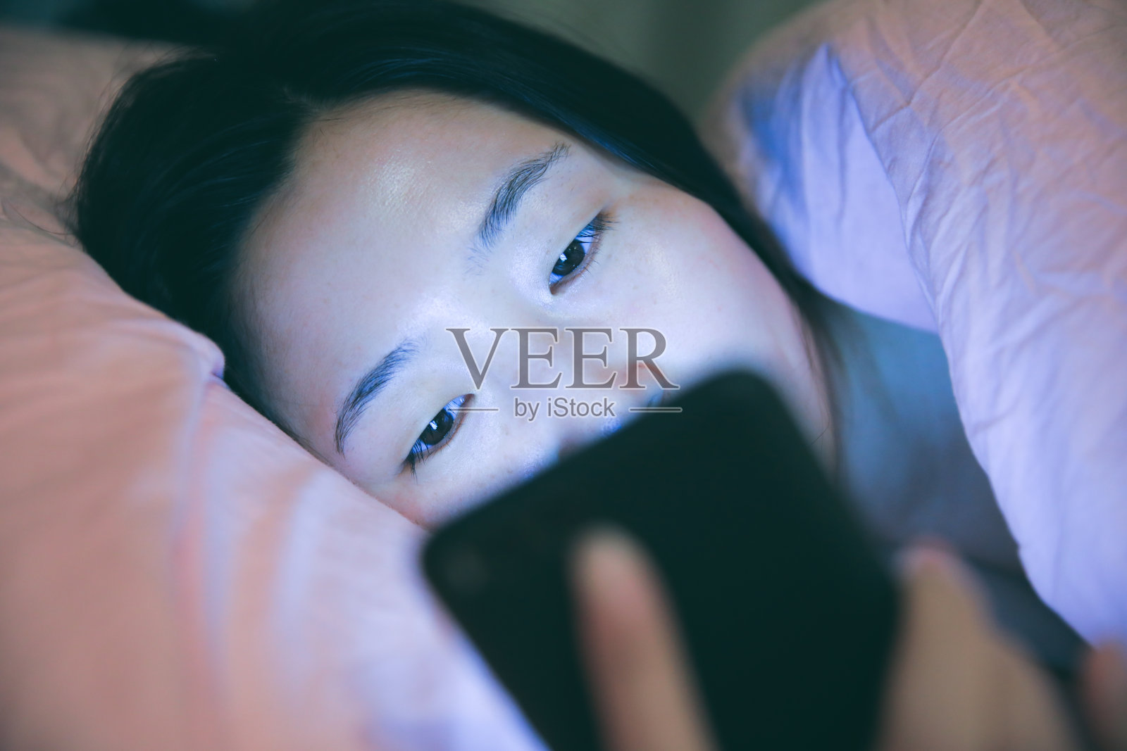 女人在床上玩智能手机照片摄影图片