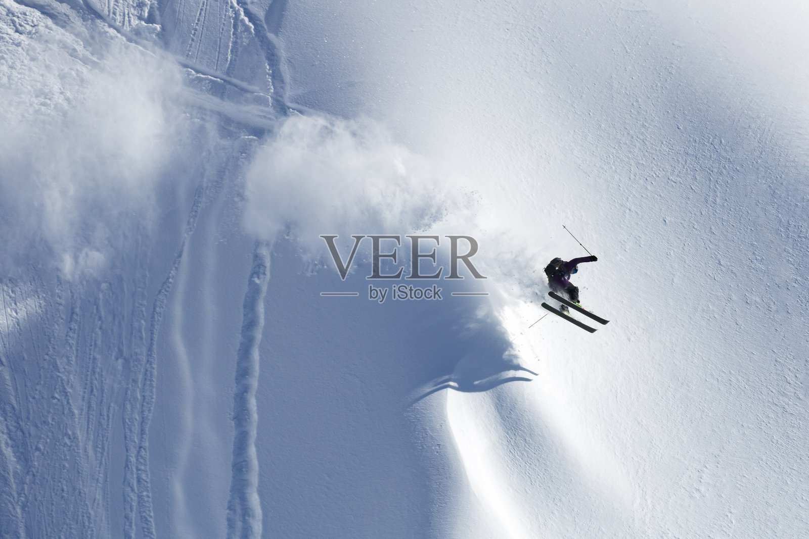 在阳光明媚的高山山坡上表演滑雪特技的男子运动员照片摄影图片