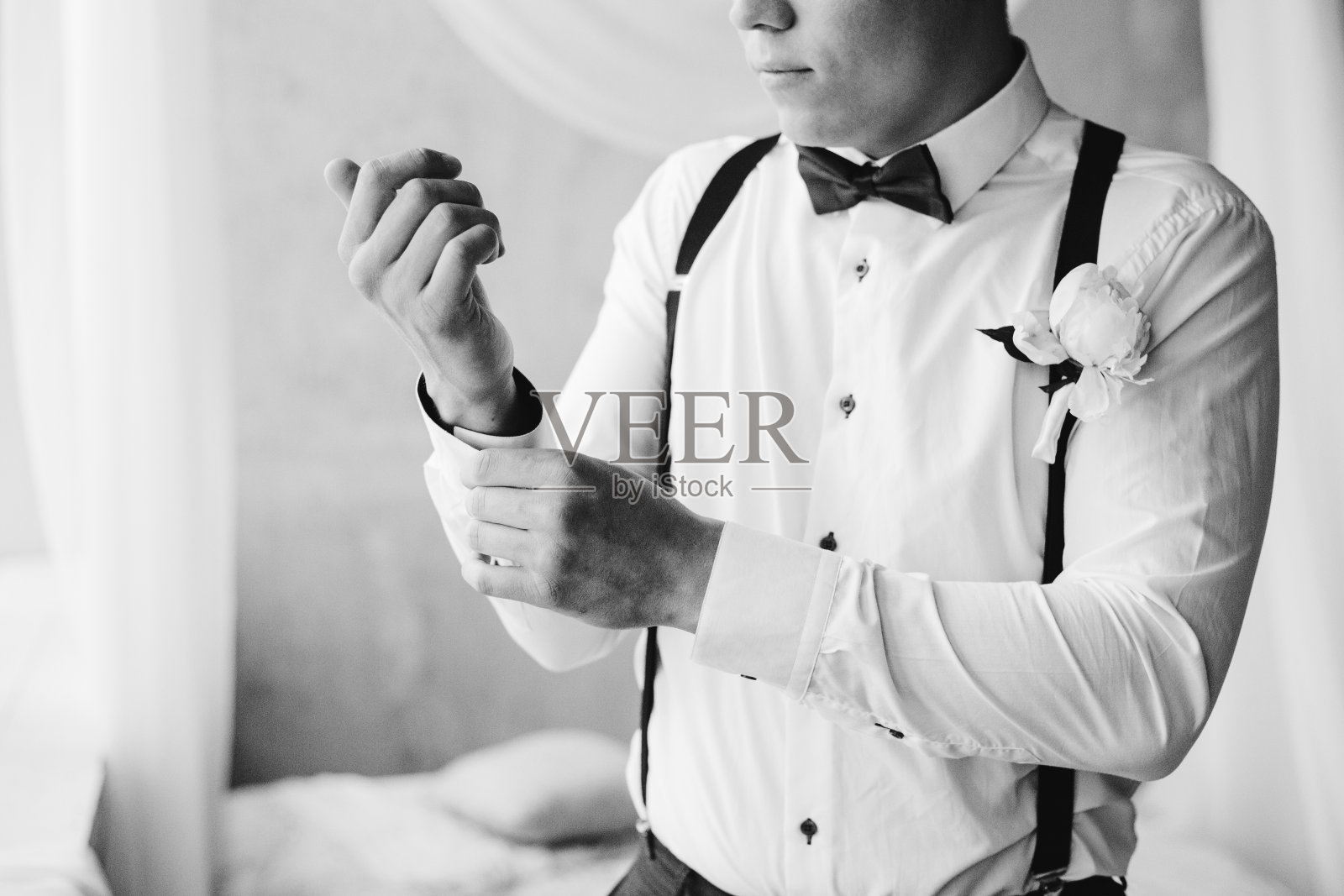 新郎早上准备英俊的新郎在酒店领结吊带打扮和准备婚礼新郎戴袖扣在白衬衫黑白肖像照片摄影图片