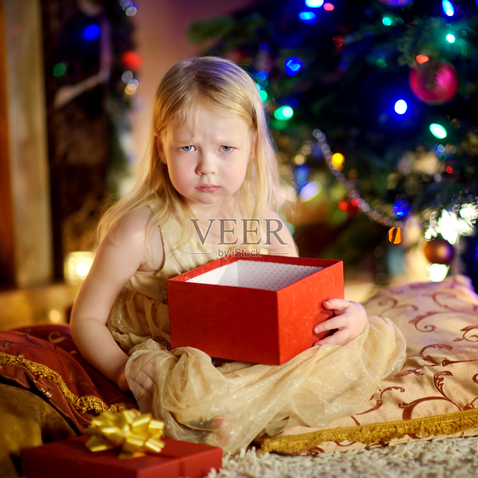 可爱的小女孩对她的圣诞礼物不满意照片摄影图片