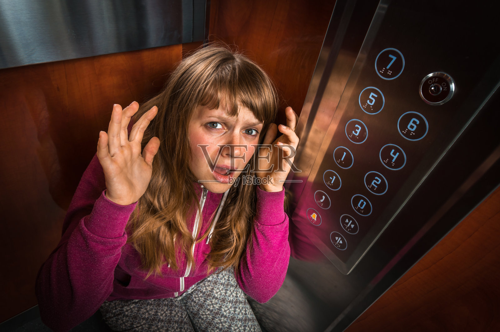 在移动的电梯里有幽闭恐怖症的震惊女人照片摄影图片