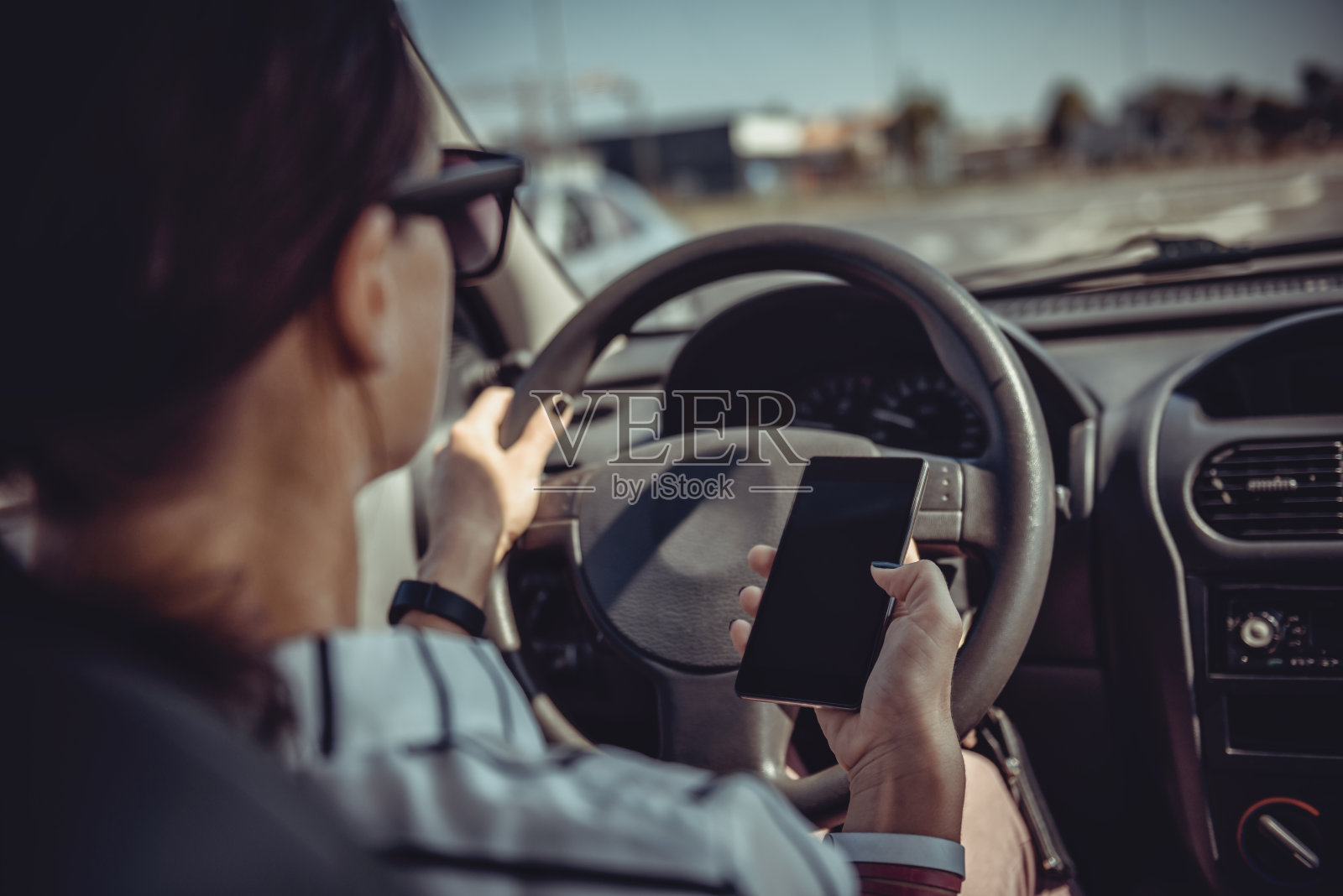 女人开车和使用智能手机照片摄影图片