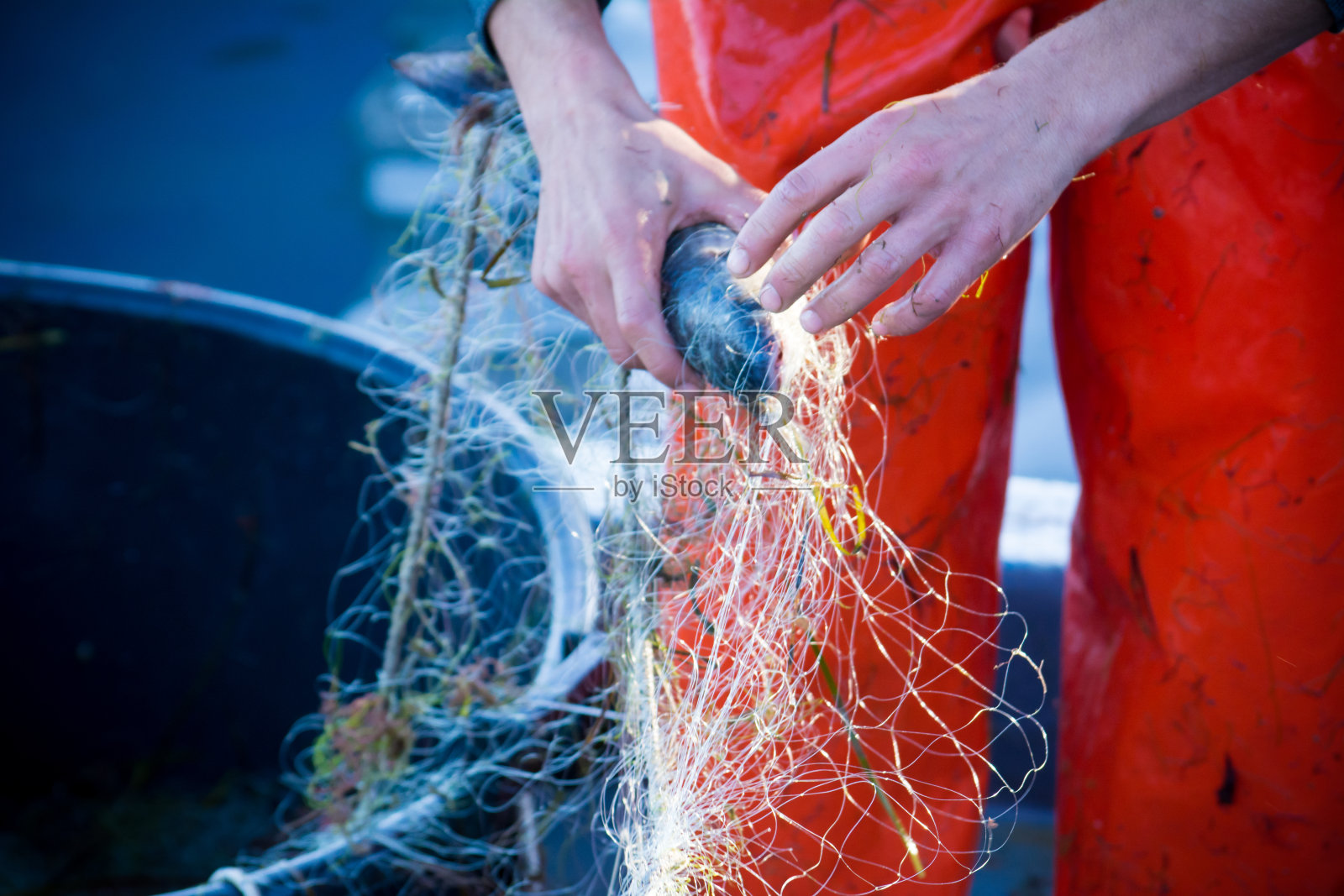渔夫在清理鱼网时照片摄影图片