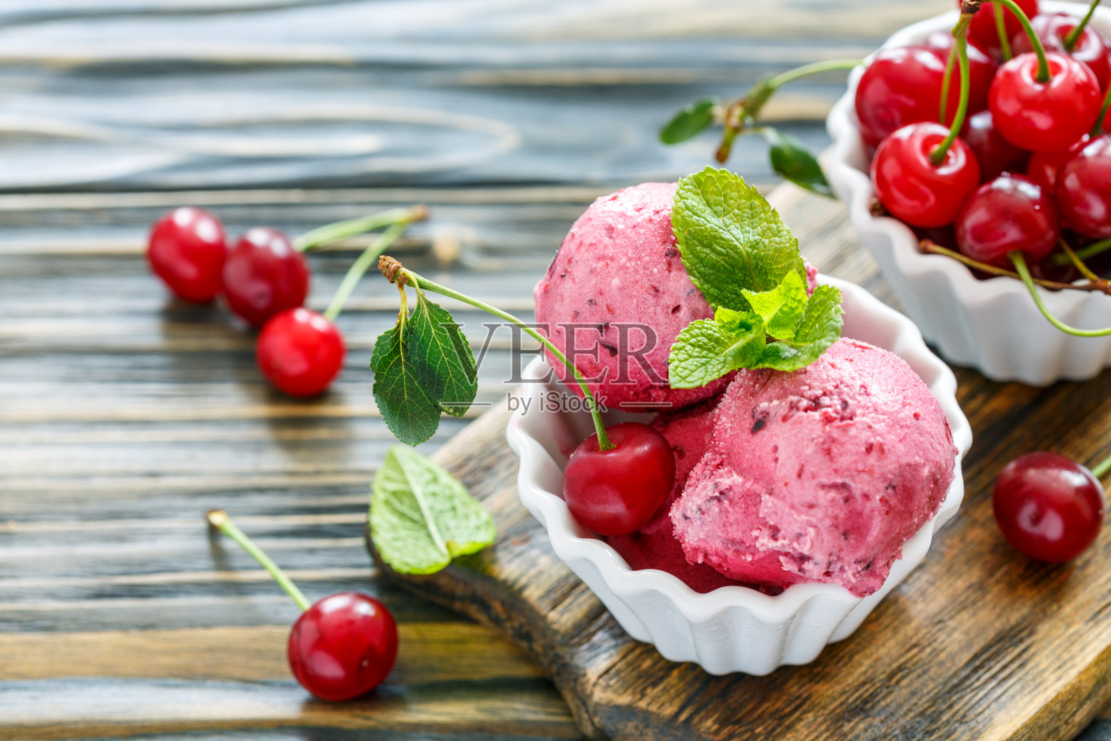 杯装自制冰淇淋和熟樱桃。照片摄影图片