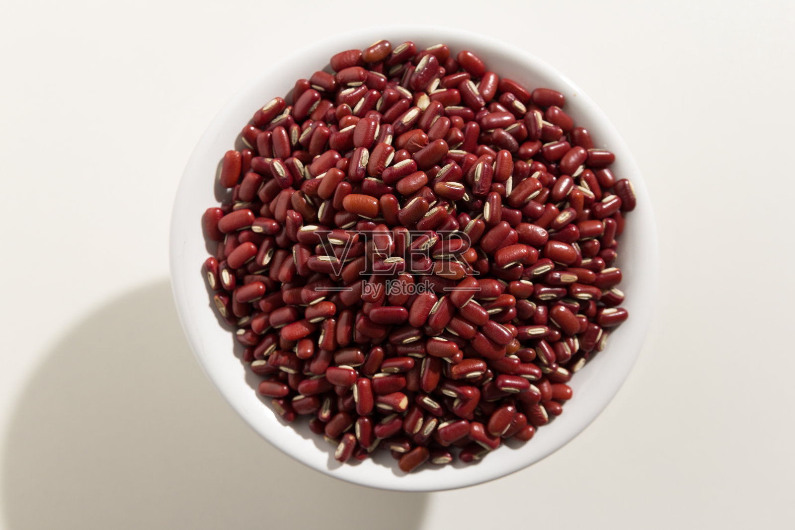 小豆是小豆的学名。也被称为红豆和日本豆。俯视图谷物在一个碗。白色背景。照片摄影图片