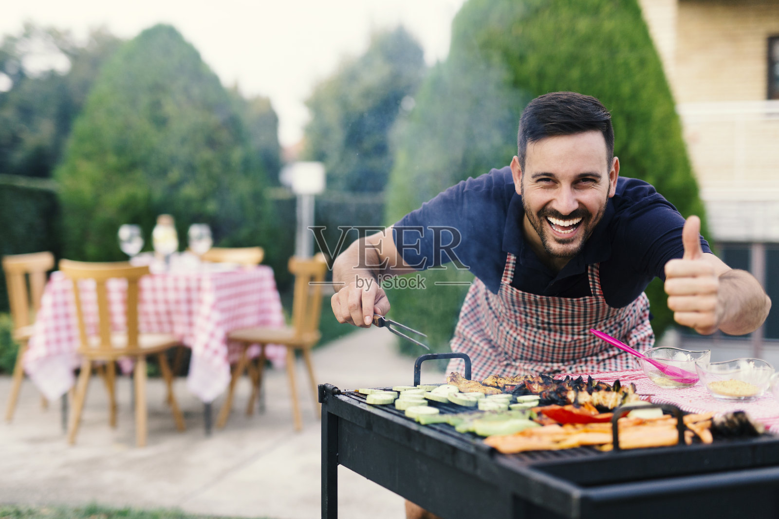 一个男人在自家后院烧烤照片摄影图片
