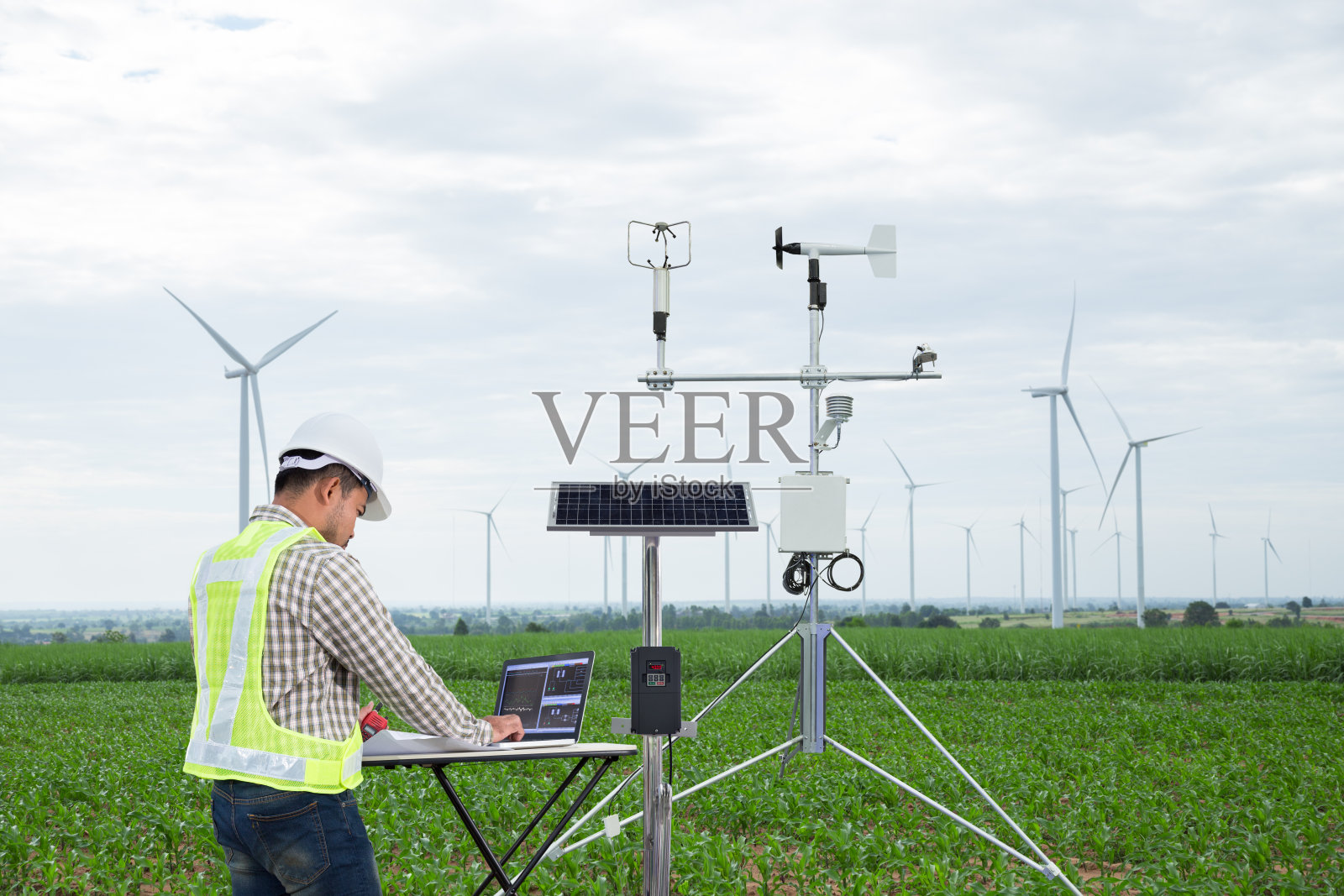 工程师利用平板电脑采集数据，利用气象仪器测量玉米田的风速、温度、湿度和太阳能电池系统，实现智能农业的技术理念照片摄影图片