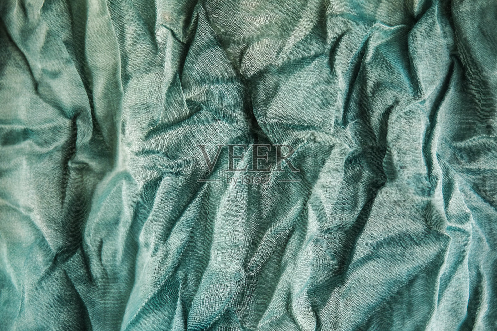 薄荷褶皱织物的质地。绿乔其面料。照片摄影图片