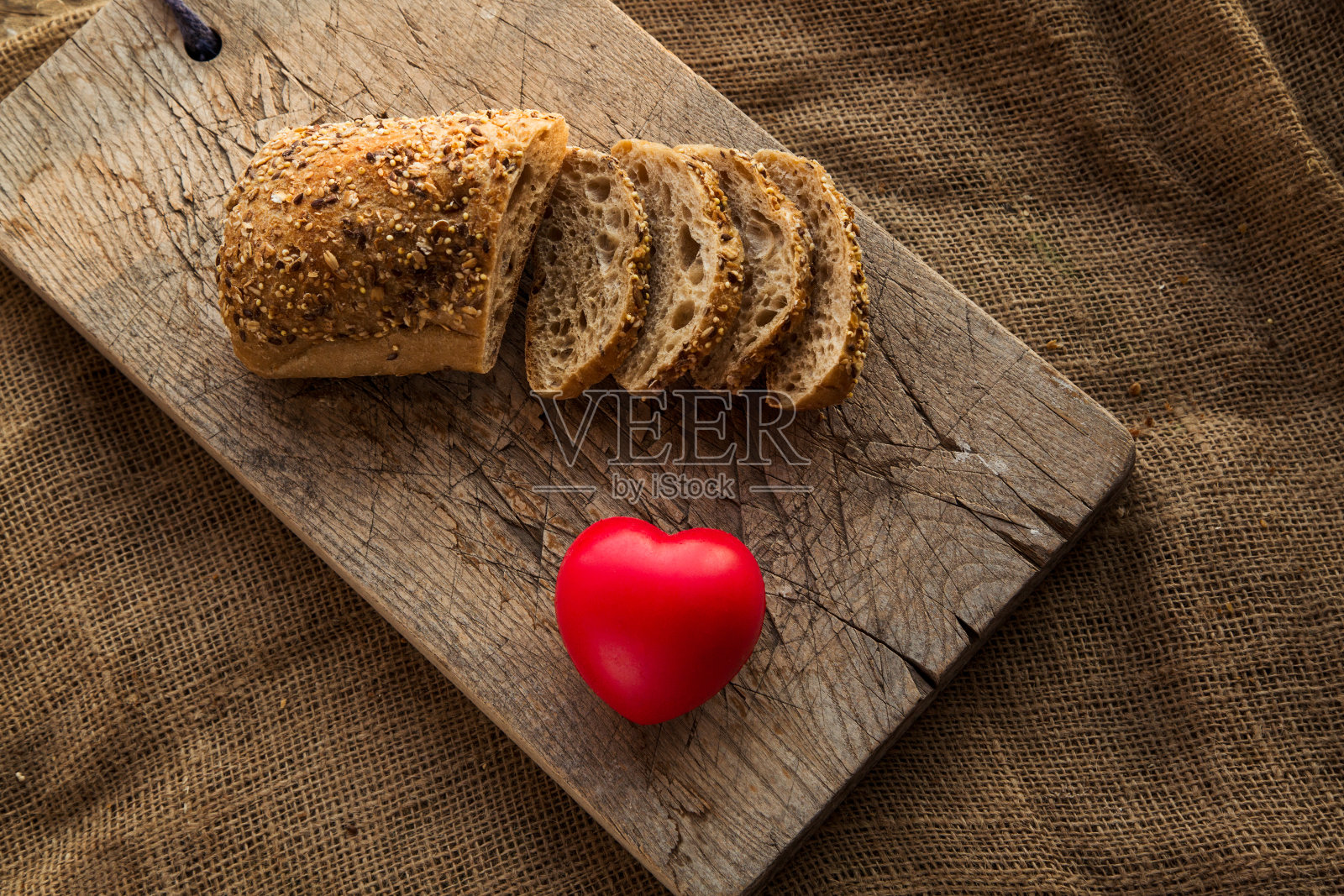 将面包切在切菜板上，切成红心形状照片摄影图片