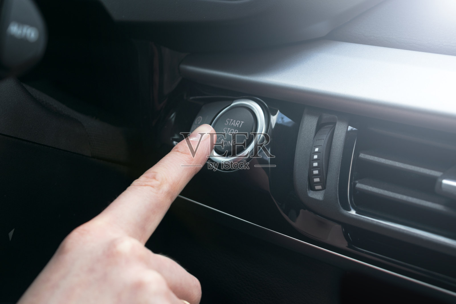 手指按按钮功能汽车发动机启动和停止在机动车预启动检查表的概念。现代汽车内部细节。柔和的灯光照片摄影图片