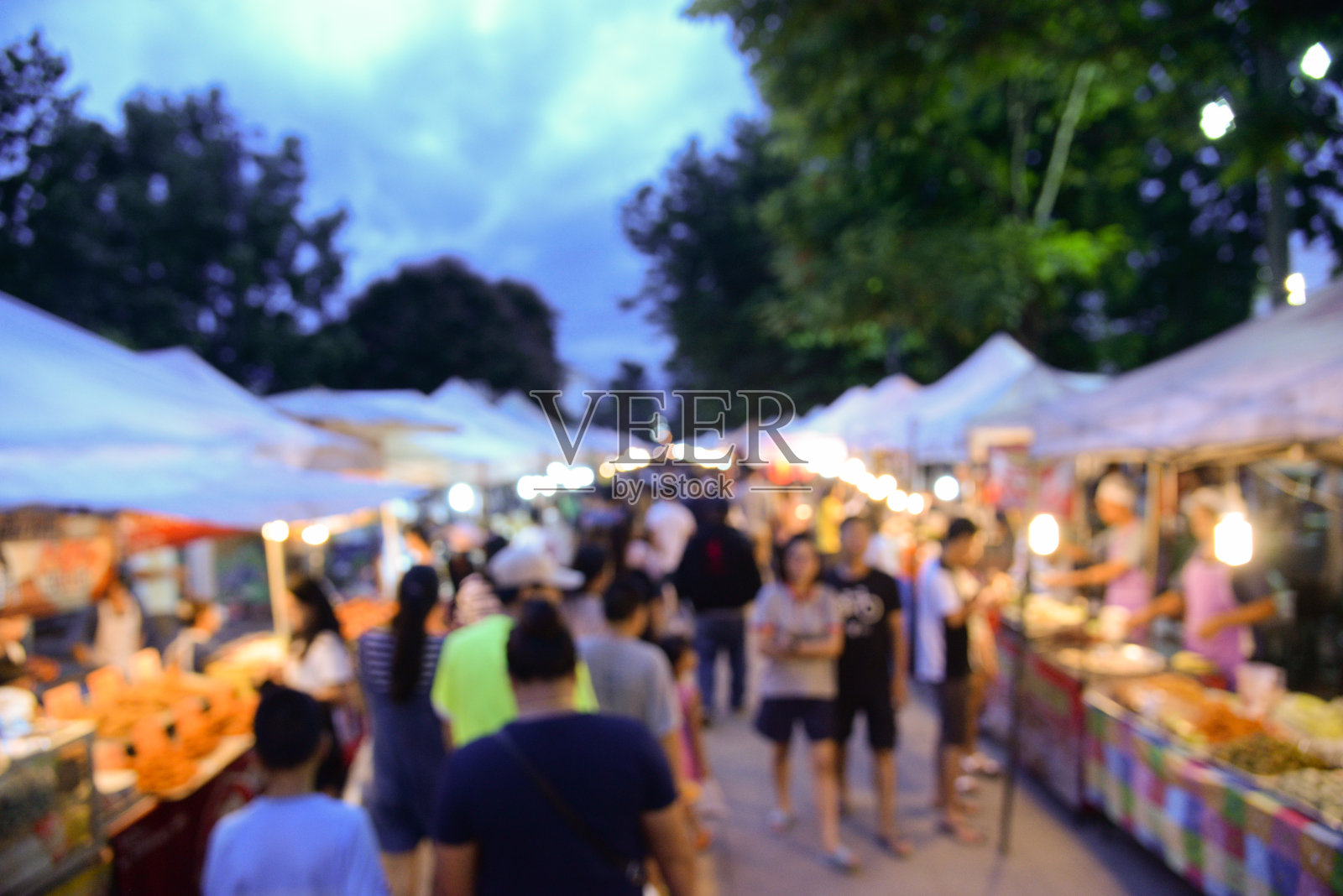 模糊背景的步行街市场在泰国曼谷。游客周末在当地市场购物照片摄影图片