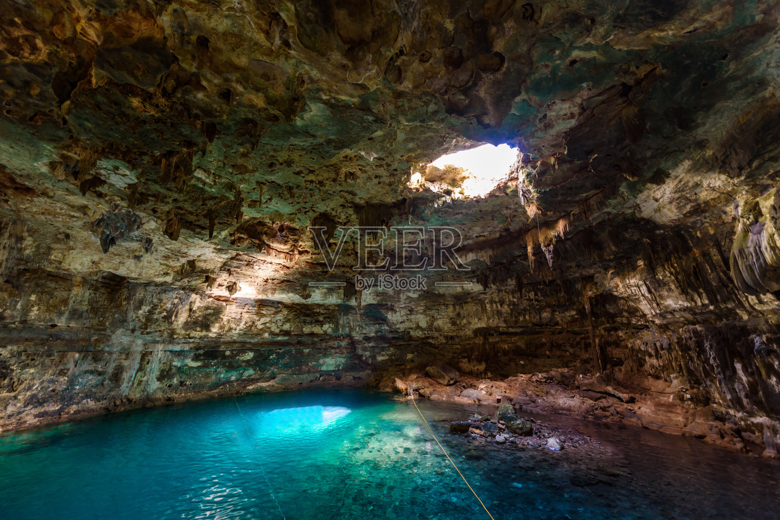 墨西哥尤卡坦半岛巴利亚多利德附近的萨穆拉Dzitnup天然井，在清澈湛蓝的水中游泳照片摄影图片