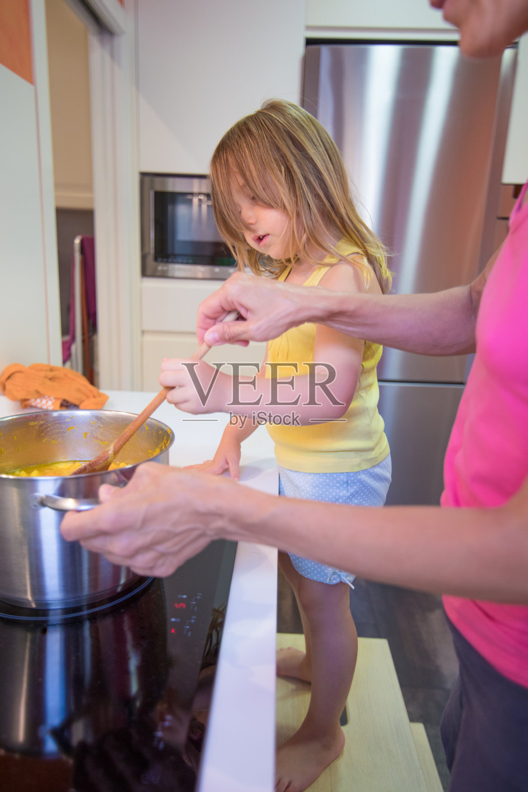 小女孩在厨房帮她妈妈做饭照片摄影图片