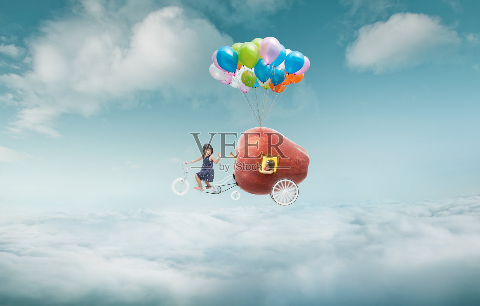 快乐的姐姐享受与幻想苹果骑自行车和漂浮在天空与一束彩色气球。照片摄影图片