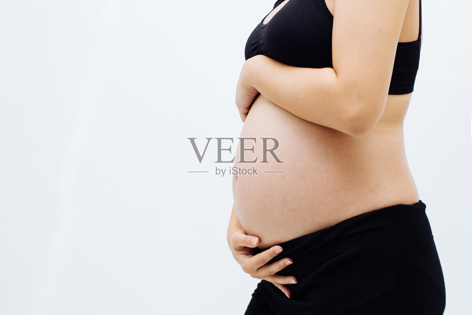 孕妇触摸她怀孕的腹部在白色孤立的背景与复制空间照片摄影图片