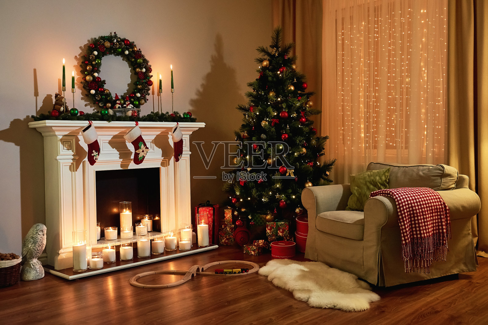 圣诞房室内设计，圣诞树装饰灯，礼品玩具，蜡烛和花环照明室内壁炉。圣诞假期客厅。新年的设计。照片摄影图片