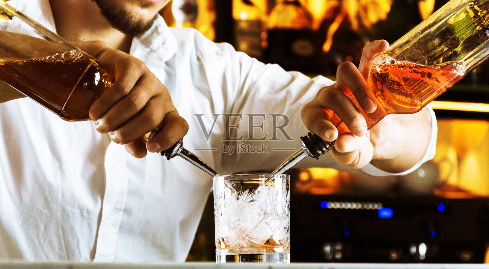 专业的酒吧为他的客人准备混合饮料。照片摄影图片