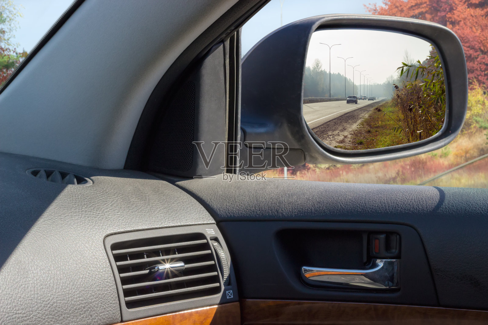 在秋天的汽车后视镜里反射高速公路照片摄影图片