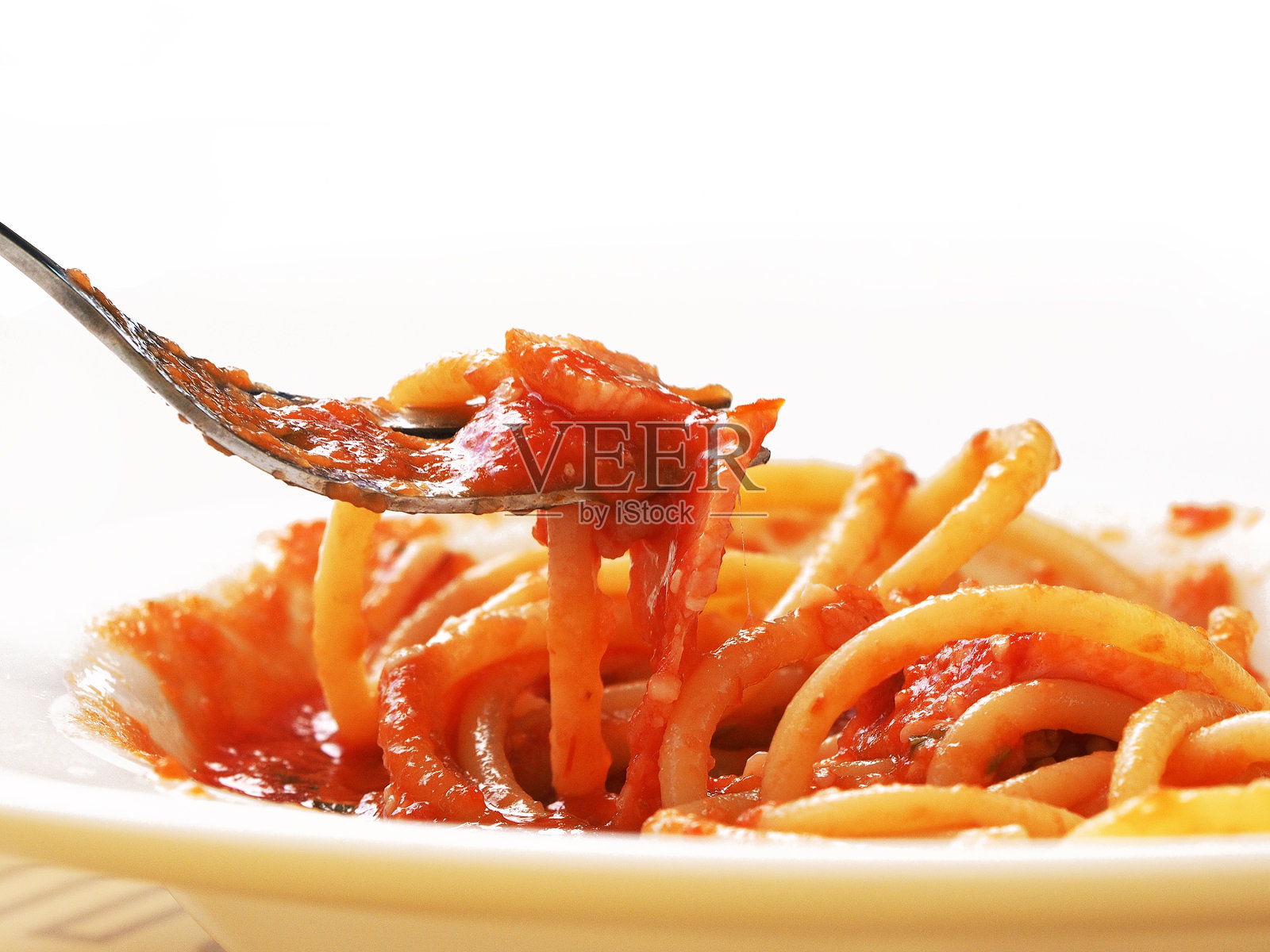 新鲜热的意大利面和番茄酱放在叉子上，特写，意大利面在盘子里。孤立在白色背景上照片摄影图片