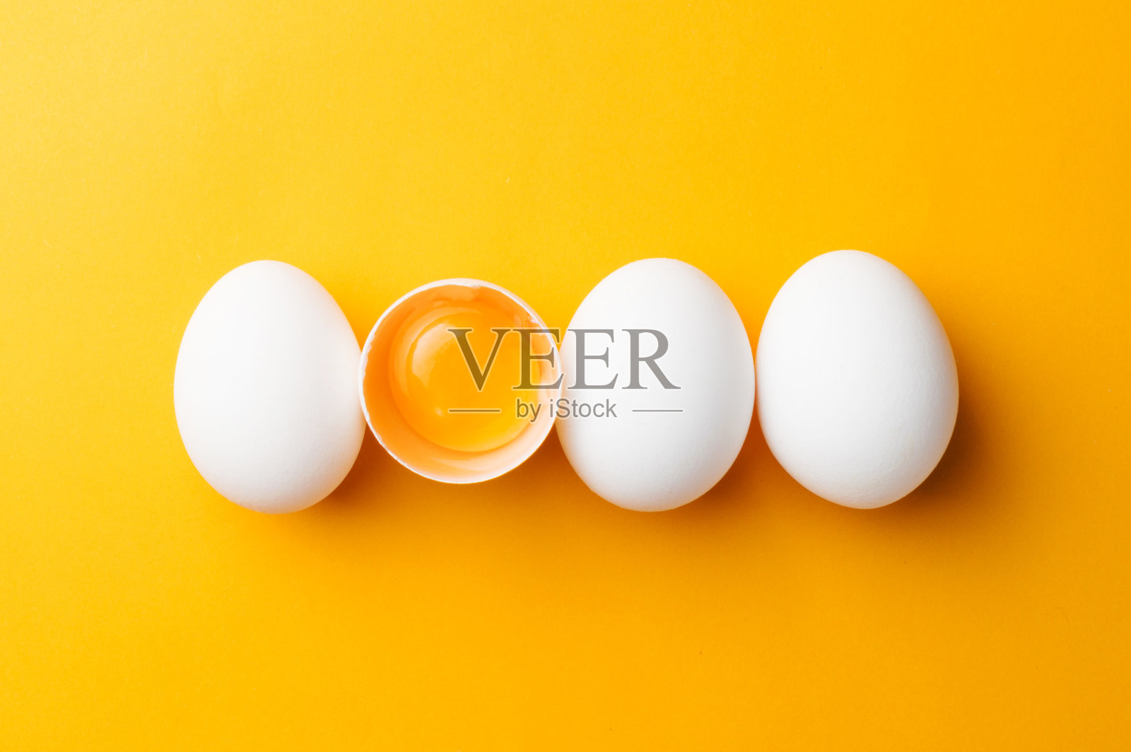 白色的鸡蛋和蛋黄在黄色的背景。赢富数据照片摄影图片